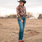 model standing in field wearing a fashionable modern western outfit