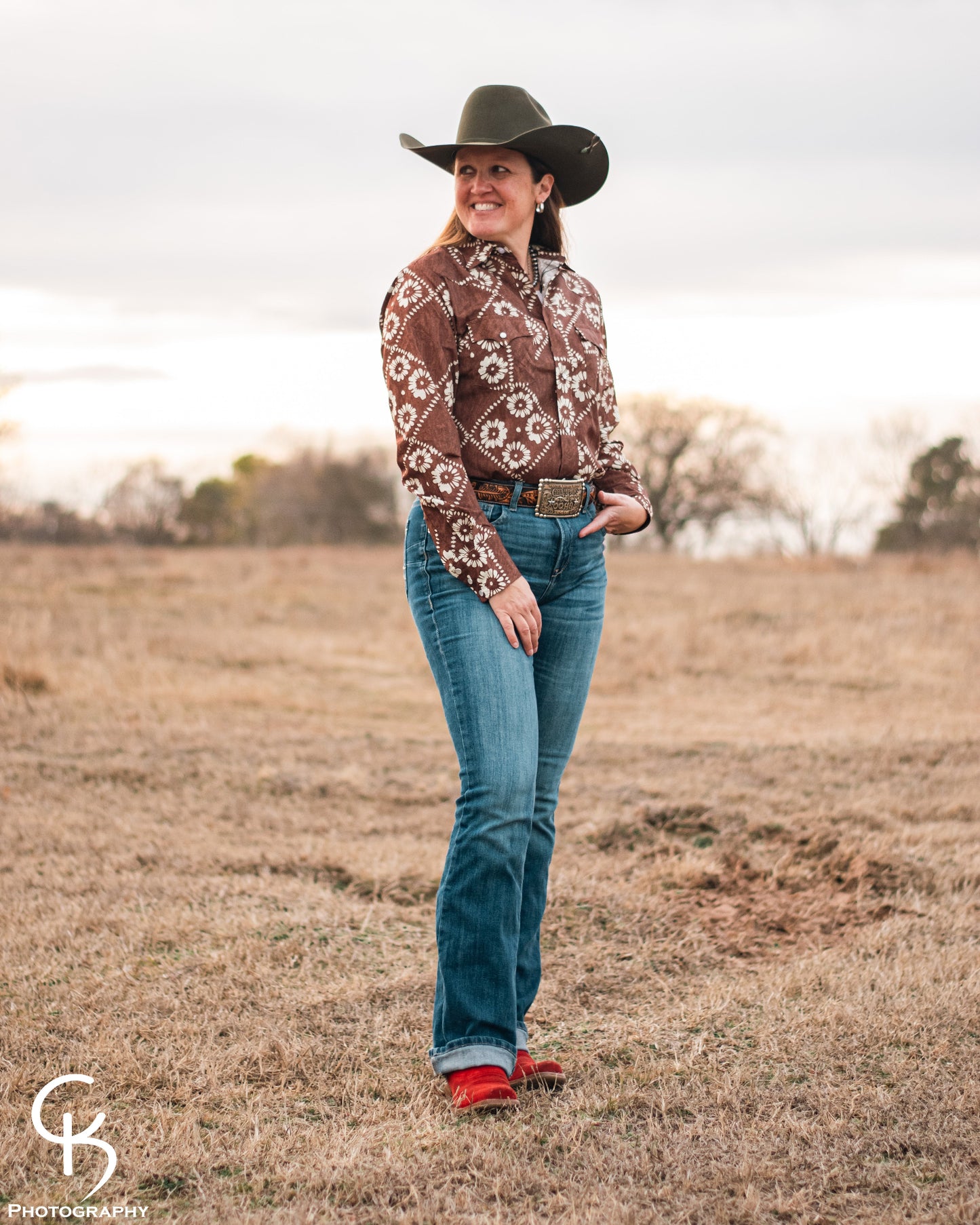 model standing in field wearing a fashionable modern western outfit