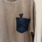Beige sweatshirt with a denim pocket and hanger on a white background