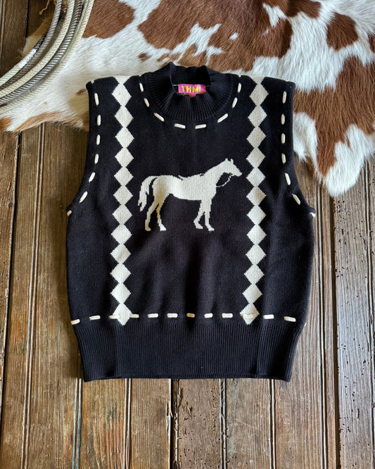 Black sweater vest with horse design on a wooden surface with cowhide rug