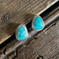 Turquoise stone earrings on a wooden surface