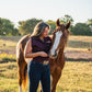 woman with horse standing in a pasture