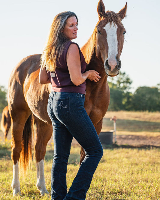 Woman standing next to a horse in an outdoor setting