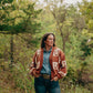 Woman wearing a patterned cardigan in a forest setting