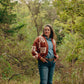 Woman wearing a patterned cardigan in a forest setting
