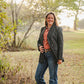 Woman standing in a field with trees in the background