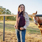 Woman standing next to a horse in an outdoor setting