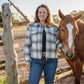 Woman standing next to a horse in a rural setting