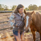 Woman standing next to a horse in an outdoor setting