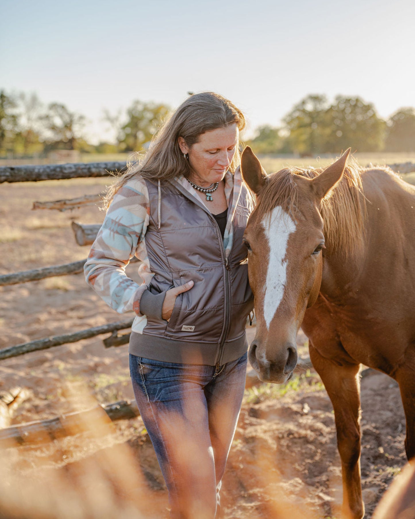 Woman standing next to a horse in an outdoor setting