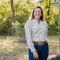 Woman standing outdoors with trees in the background