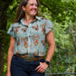 Woman wearing a patterned shirt with nature in the background