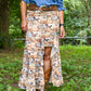 Person wearing a patterned skirt with animal designs outdoors.