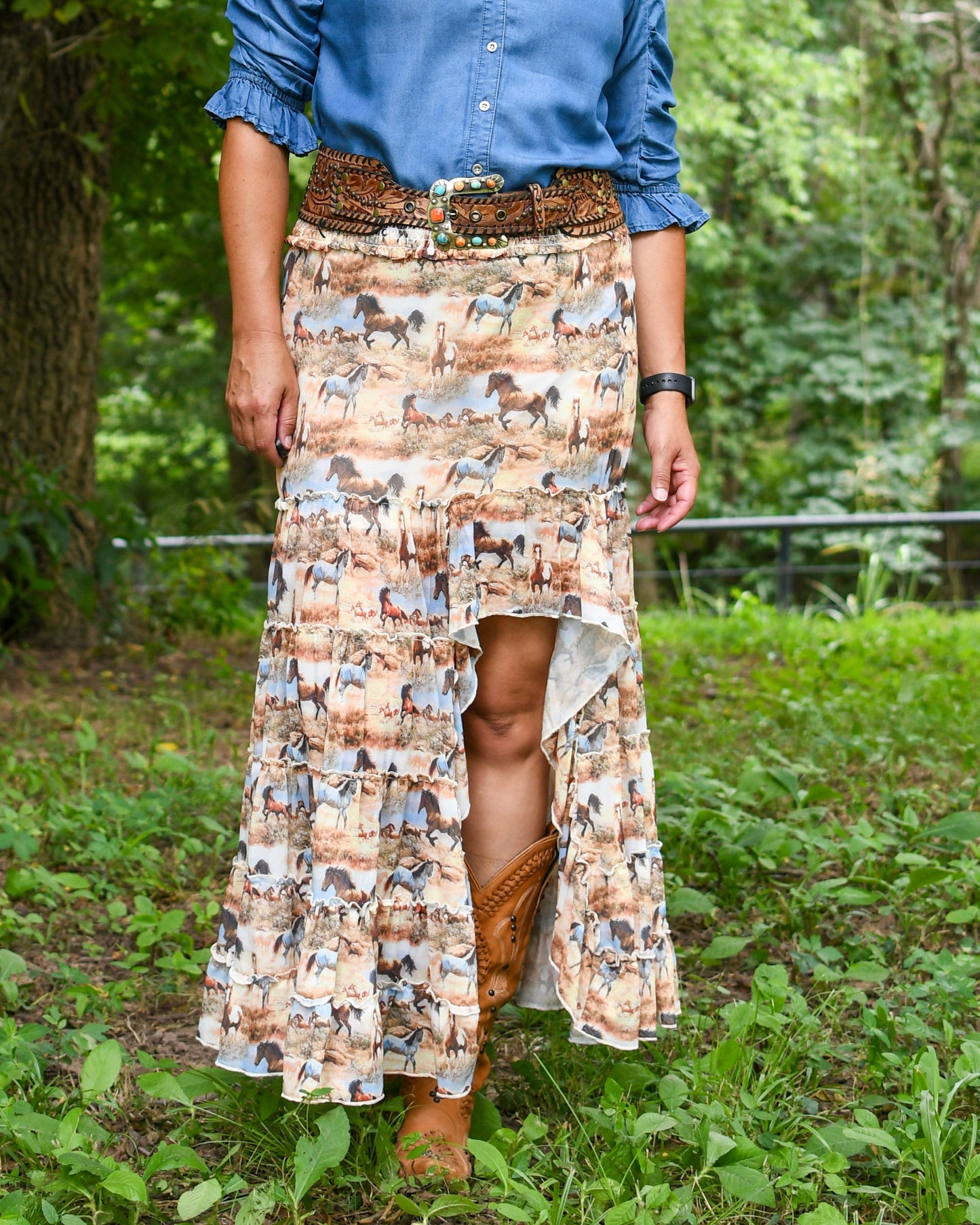 Person wearing a patterned skirt with animal designs outdoors.
