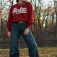 Model in sweater and jeans standing in trees