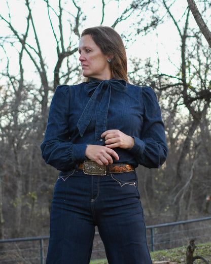 woman wearing all denim standing by a tree