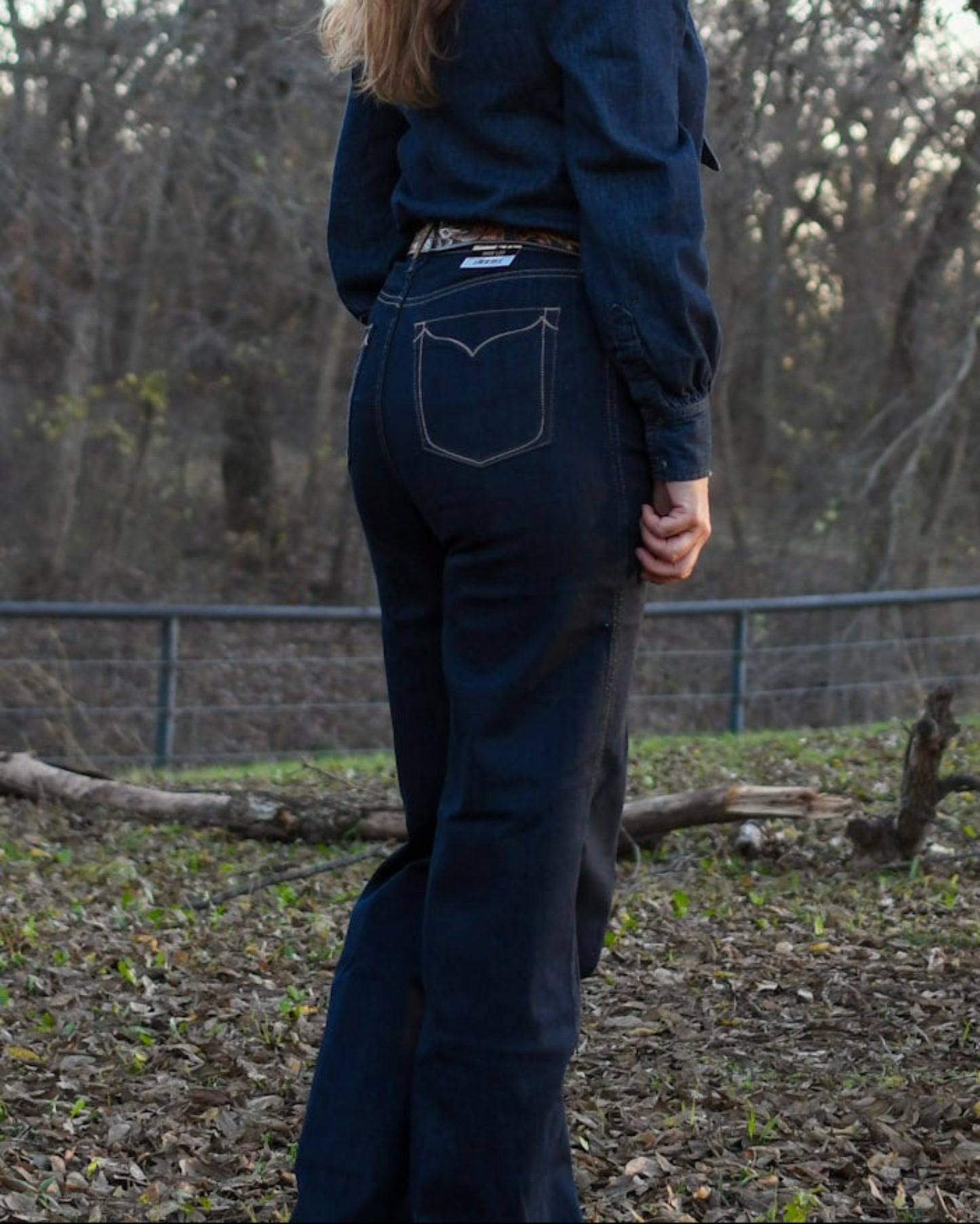 Model wearing denim standing in trees