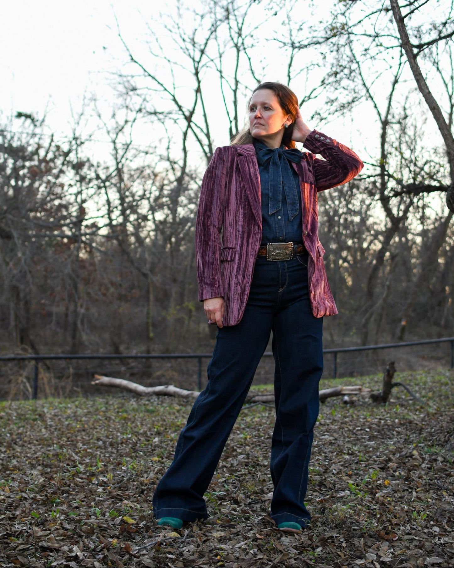Woman standing outside wearing a blazer and jeans 