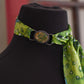 Mannequin head with a black cap and green patterned scarf