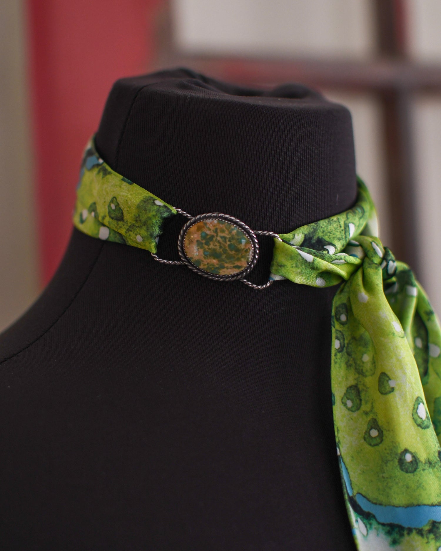 Mannequin head with a black cap and green patterned scarf