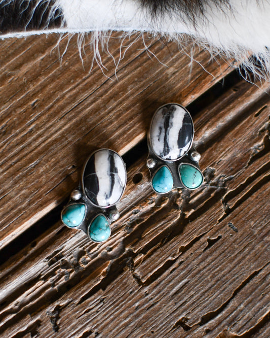White Buffalo & turquoise earrings on a rustic wooden background 