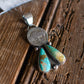 Silver pendant with turquoise stones on a wooden surface
