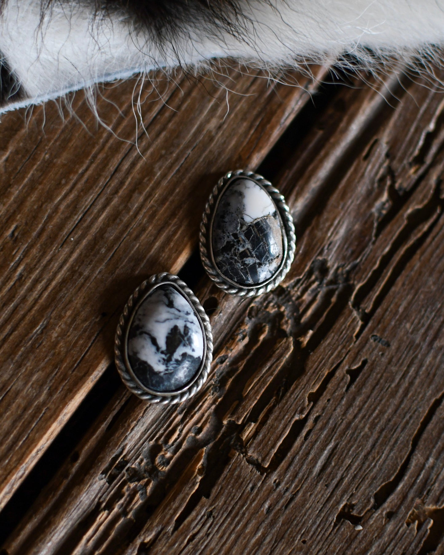 White buffalo earrings on a rustic wooden background