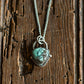 Silver necklace with green stone on rustic wooden background