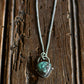 Necklace with a heart-shaped turquoise pendant on a wooden surface
