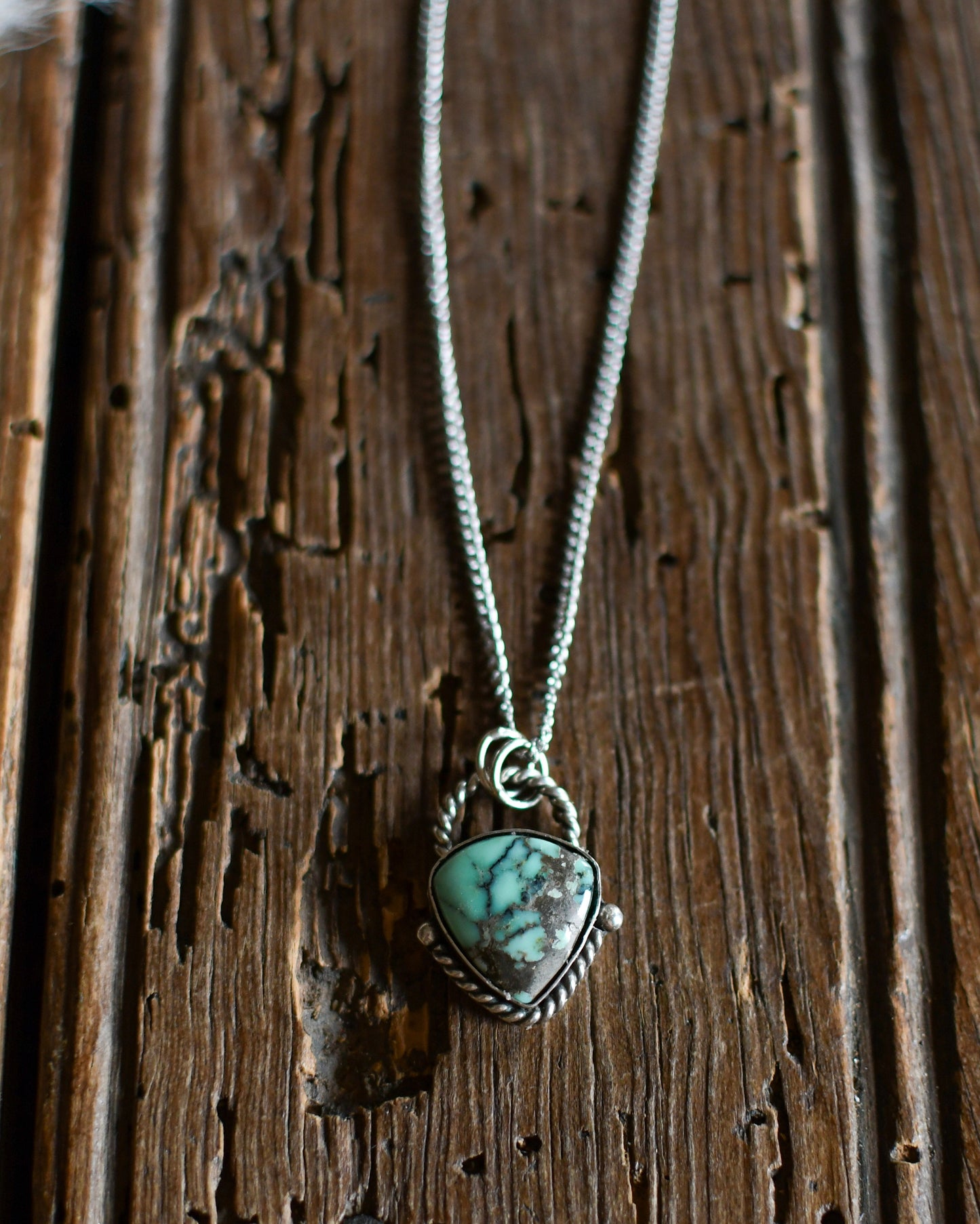 Necklace with a heart-shaped turquoise pendant on a wooden surface
