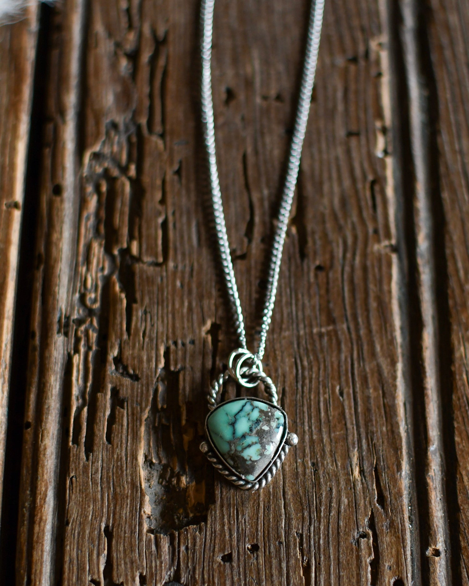 Necklace with a heart-shaped turquoise pendant on a wooden surface