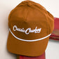 close up of hat hanging on door with white background