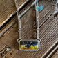 Necklace with a rectangular pendant on a wooden surface