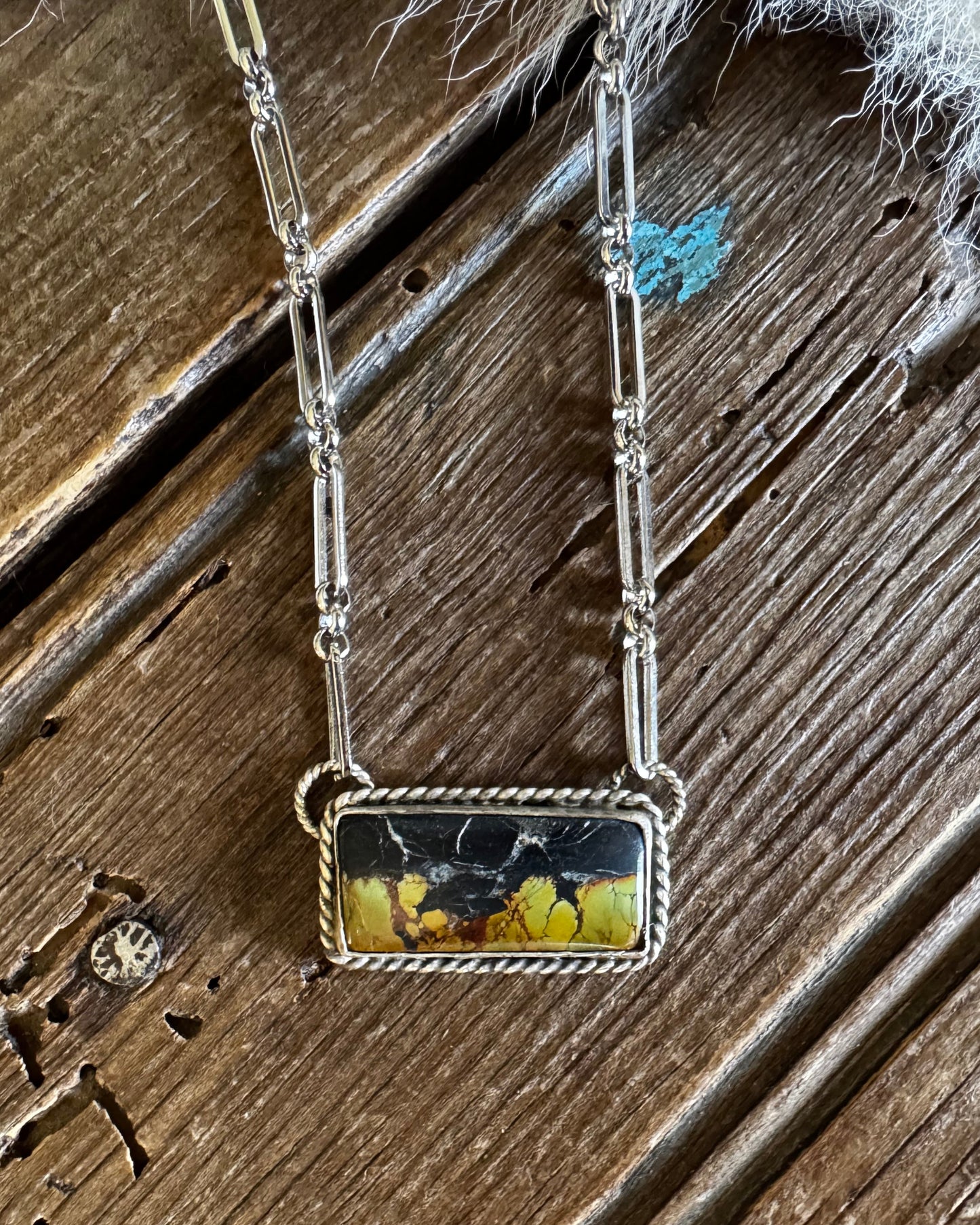 Necklace with a rectangular pendant on a wooden surface