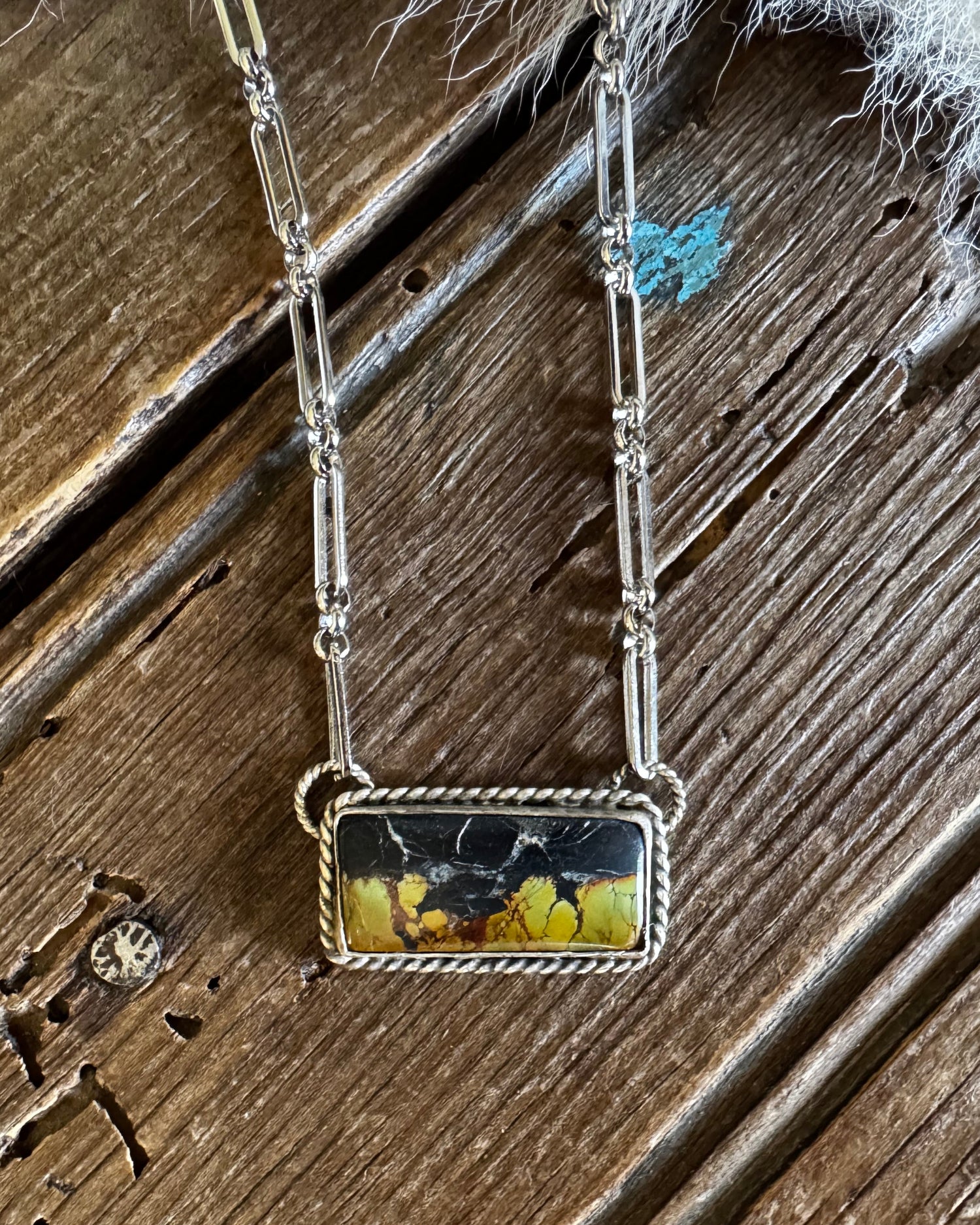 Necklace with a rectangular pendant on a wooden surface
