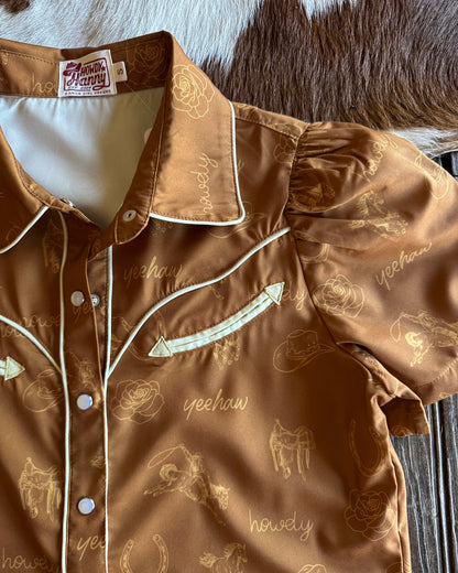 Brown shirt with designs on a wooden surface