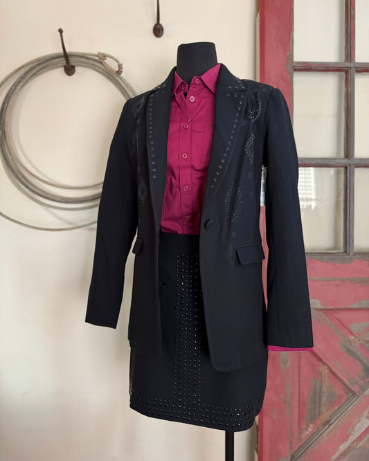 Black coat with pink shirt on a mannequin against a neutral background