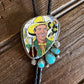 Bolo tie with a colorful design of a smiling man in a cowboy hat on a wooden surface
