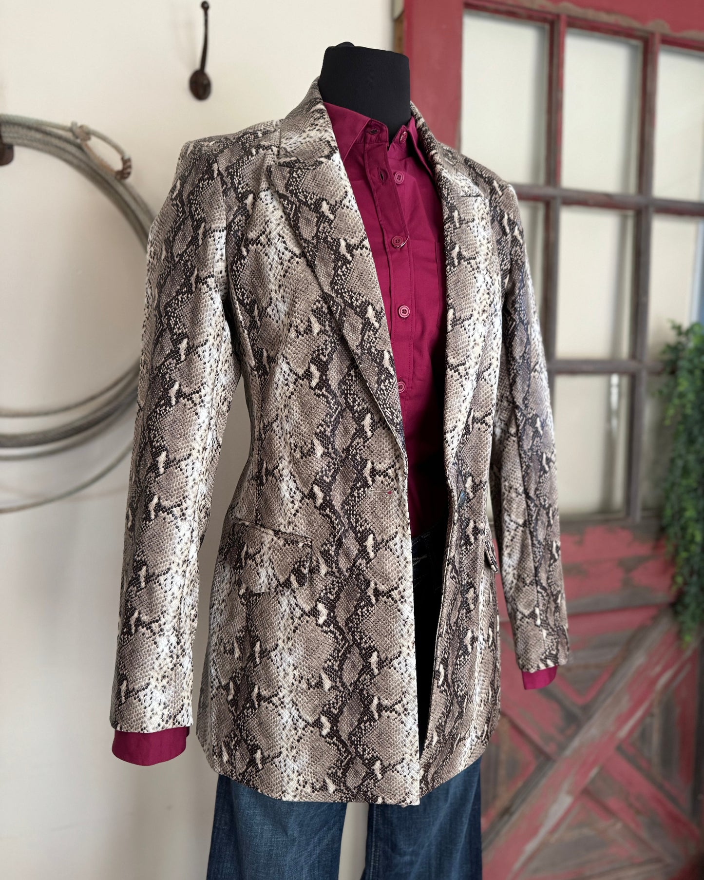 Snakeskin-patterned jacket on a mannequin against a neutral background