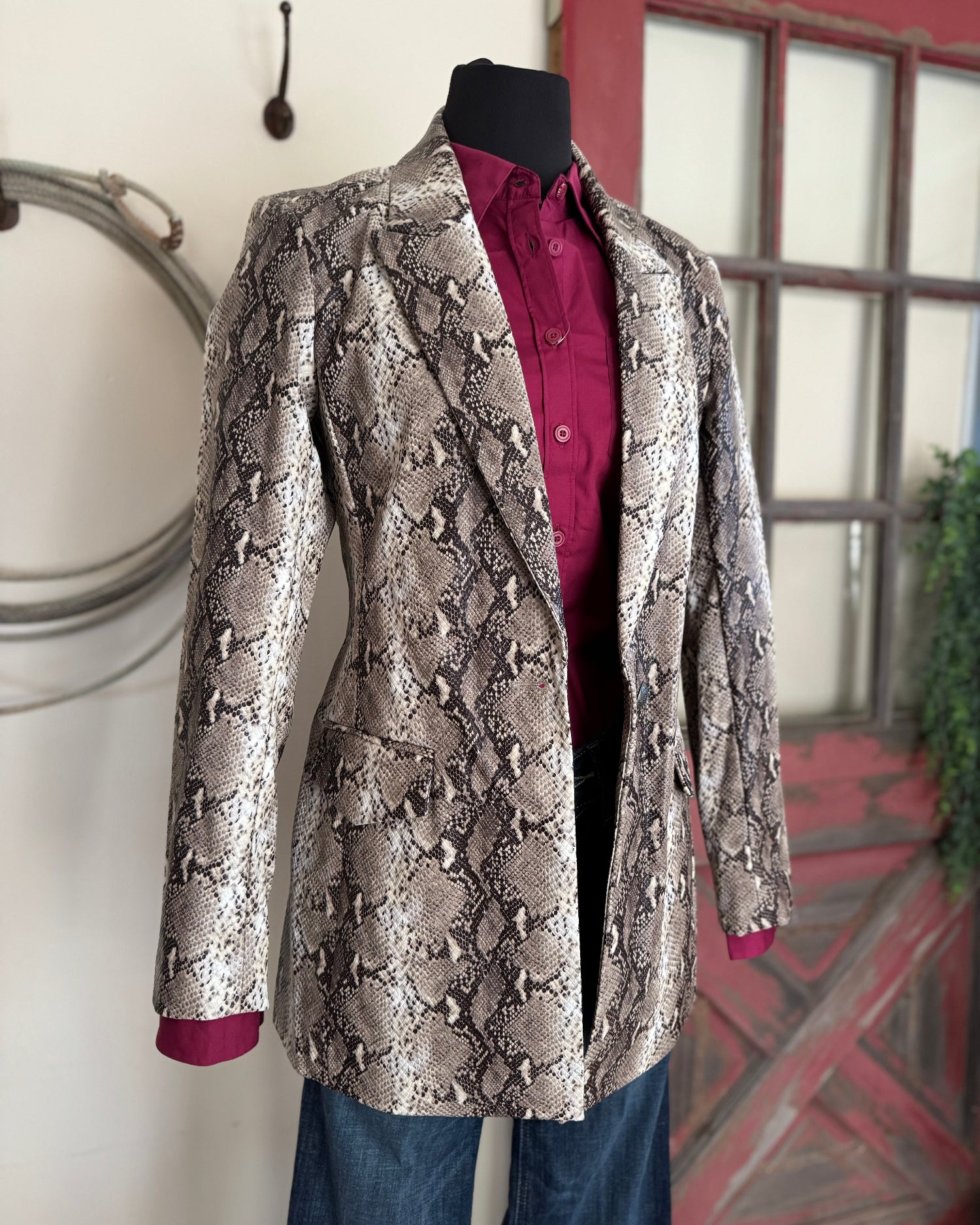 Snakeskin-patterned jacket on a mannequin against a neutral background