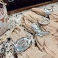 Silver cowboy boot and hat napkin rings on beige fabric with a 'Cowboy Cafe' sign in the background.