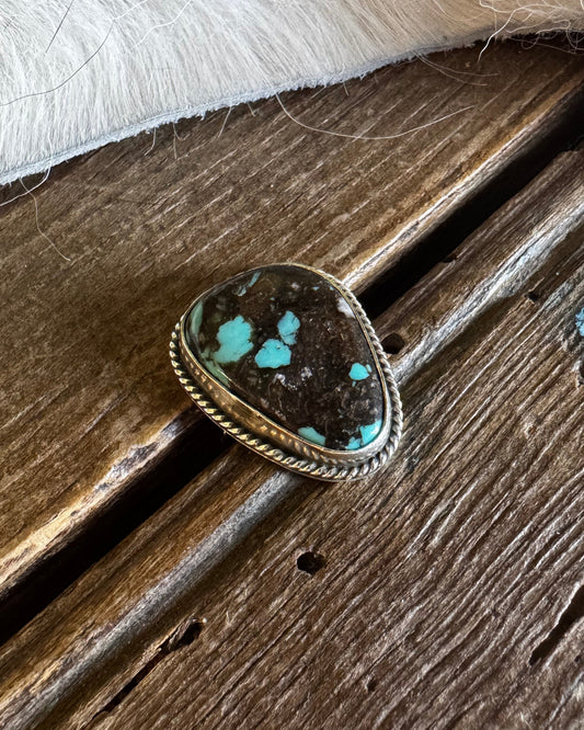 scarf slide with turquoise stone on a wooden surface