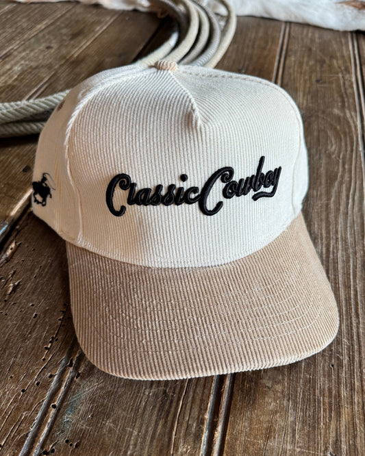 Beige and cream corduroy cap with 'Classic Cowboy' text on a wooden background