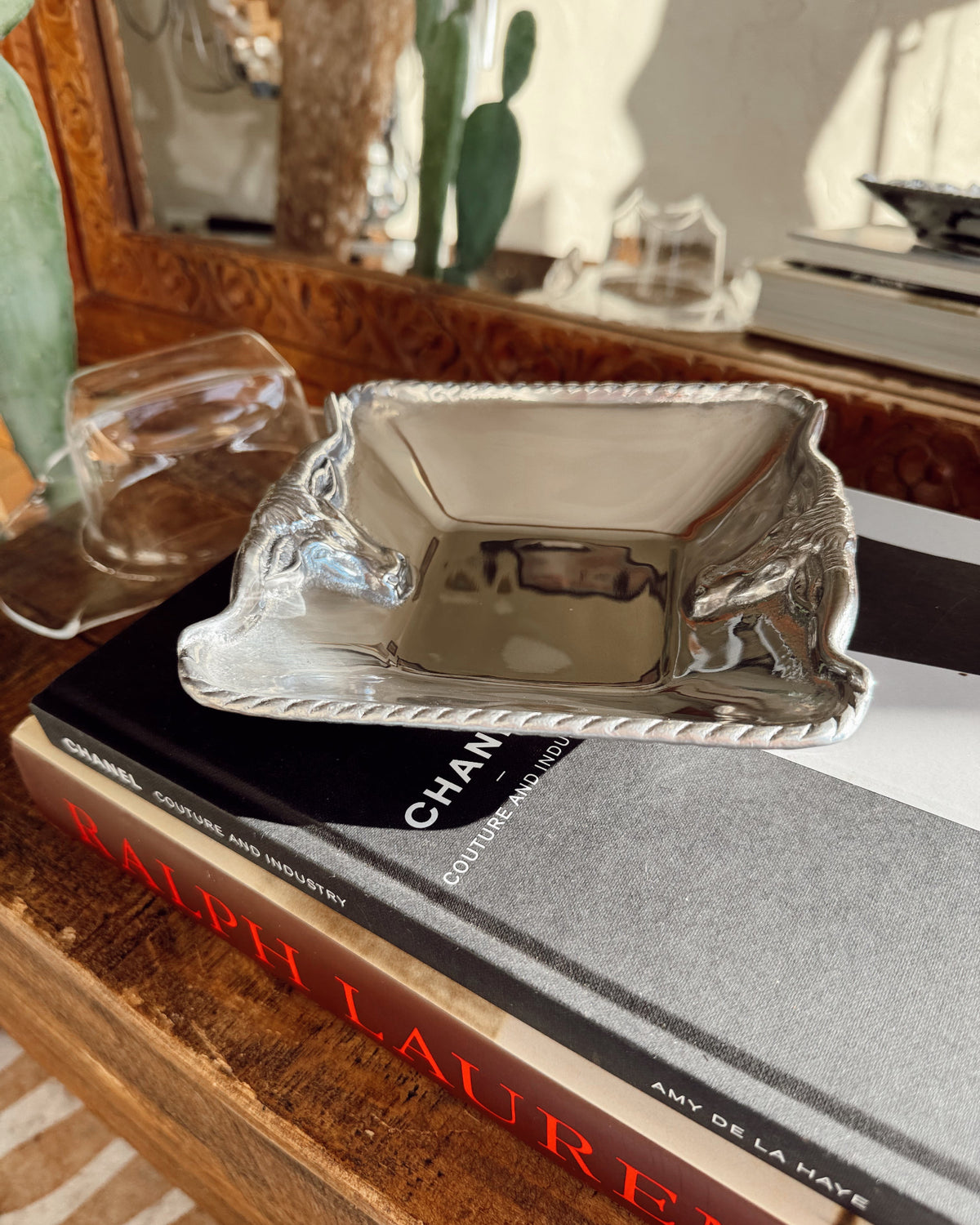 Silver tray on top of books with a blurred indoor background