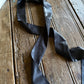 Black satin ribbon on a wooden surface