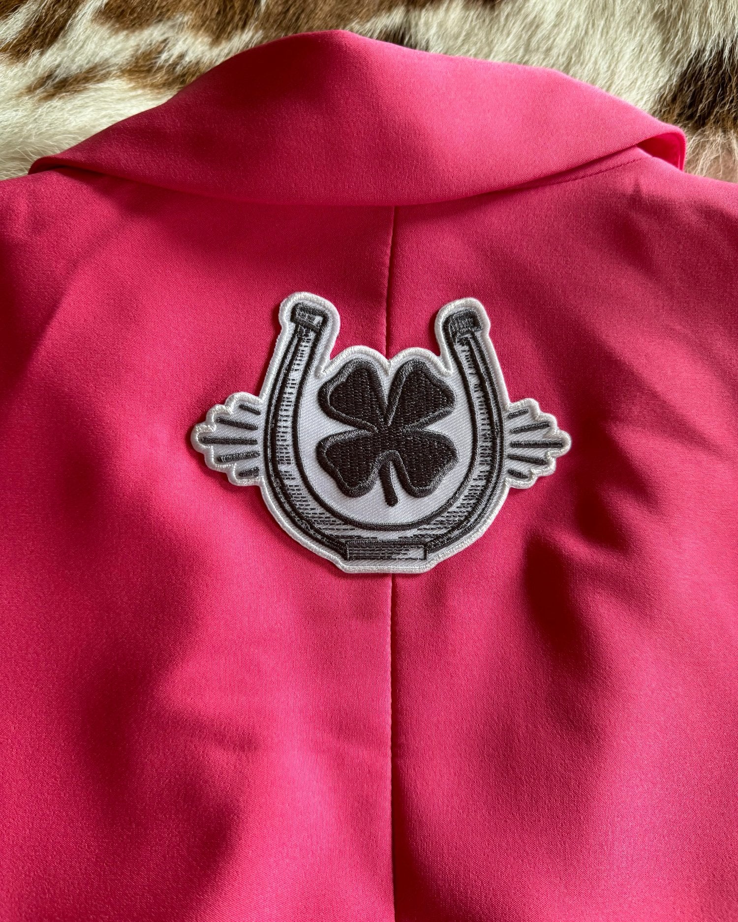 Charcoal clover and horse shoe patch on back of blazer