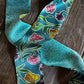 close up of teal ribbon scarf with floral design on wooden background