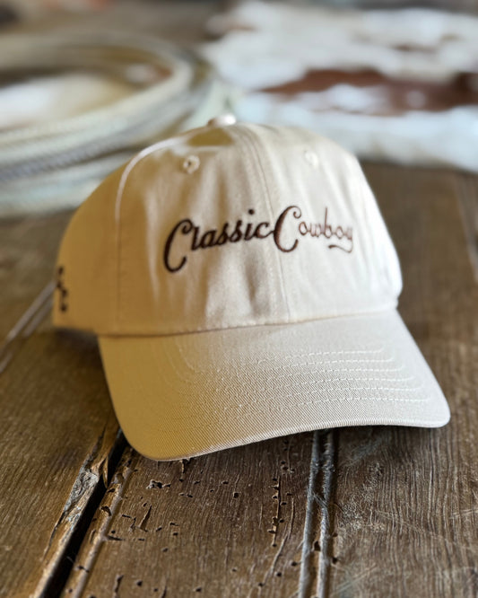 Beige cap with 'Classic Cowboy' text on a wooden surface