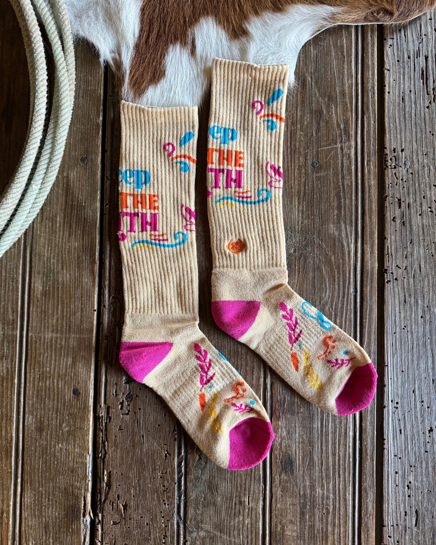 Colorful socks with text and patterns on a wooden surface