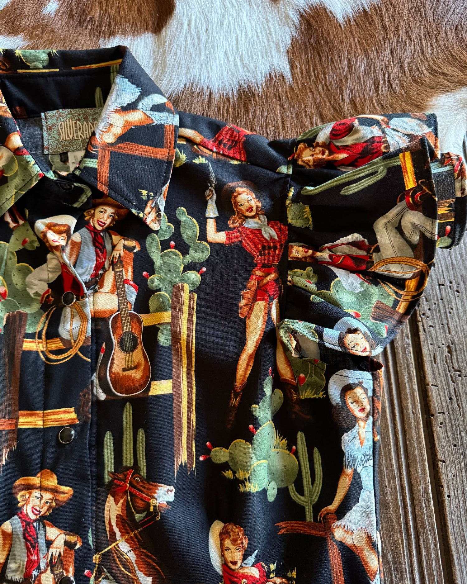 Close up of Blake Shirt (Cowgirl Pinup in Black) on rustic wood background 